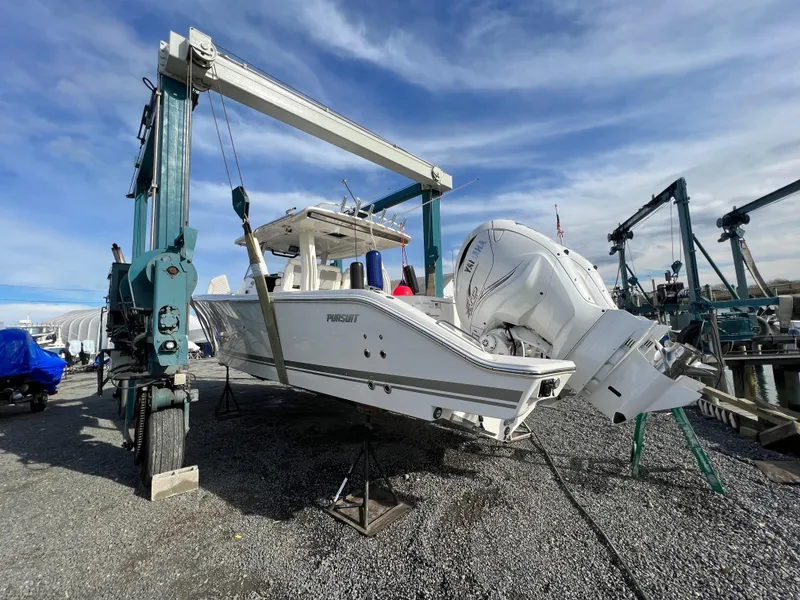 Slide: The Image of 2022 Pursuit S 358 boat being lifted by a crane at a marina. - 5