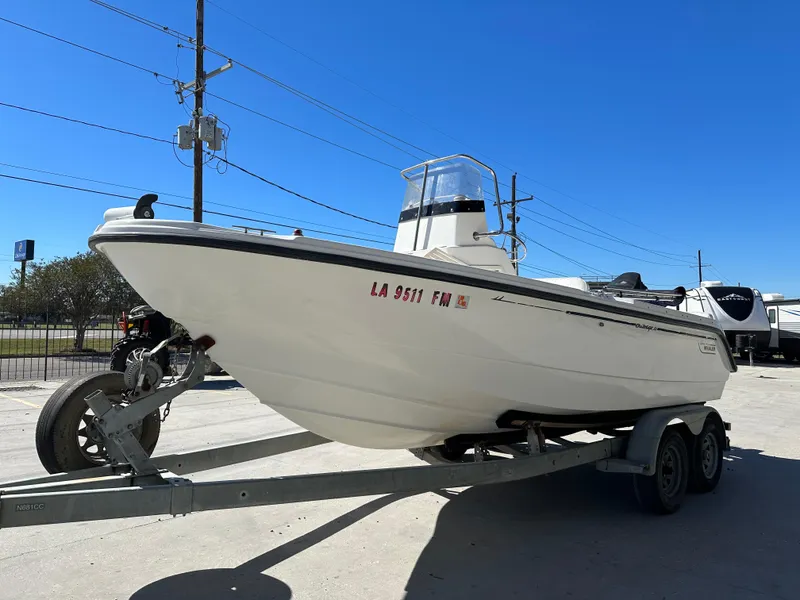 Slide: The Image of 2000 Boston Whaler Outrage 18 boat on trailer under clear blue sky. - 5