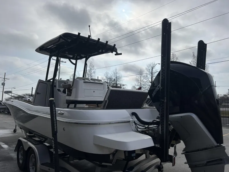 Slide: The Image of 2021 Caymas 26 HB boat with Mercury engine on trailer, under cloudy sky. - 15