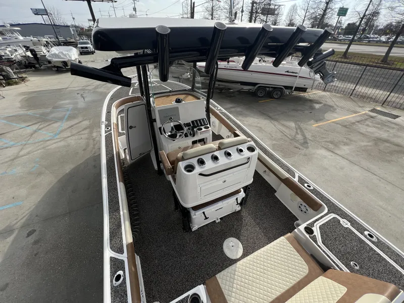 Slide: The Image of 2021 Caymas 26 HB boat with sleek design and modern console, parked outdoors. - 16