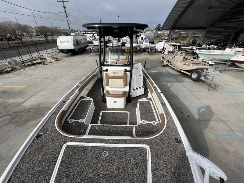 Slide: The Image of 2021 Caymas 26 HB boat with spacious deck, parked in a marina. - 18