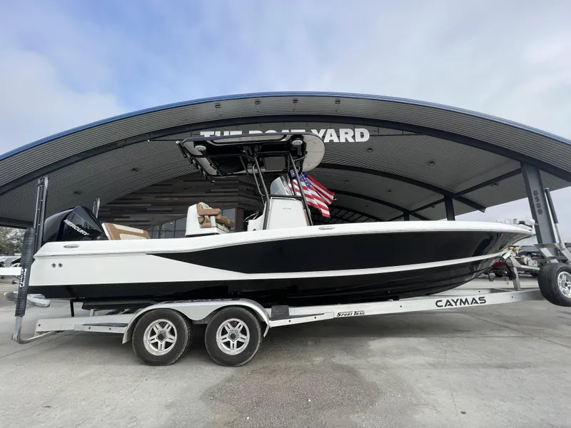 Slide: The Image of 2021 Caymas 26 HB boat on trailer at The Boat Yard, featuring sleek black and white design. - 19
