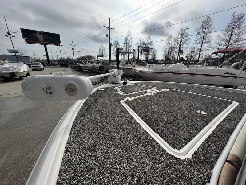 Slide: The Image of 2021 Caymas 26 HB boat deck with trolling motor, parked in a marina. - 2