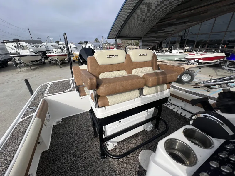 Slide: The Image of 2021 Caymas 26 HB boat interior with cushioned seating and steering console. - 5