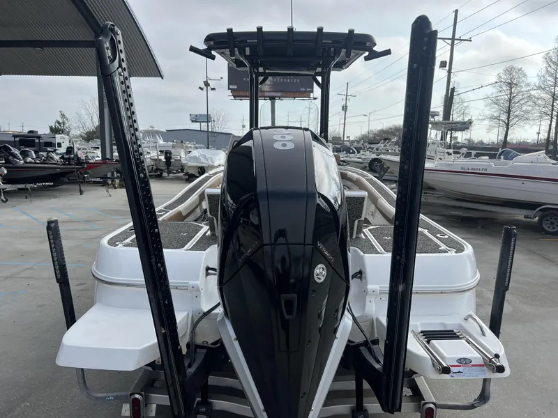 Slide: The Image of 2021 Caymas 26 HB boat with powerful outboard motor, parked in a marina. - 8