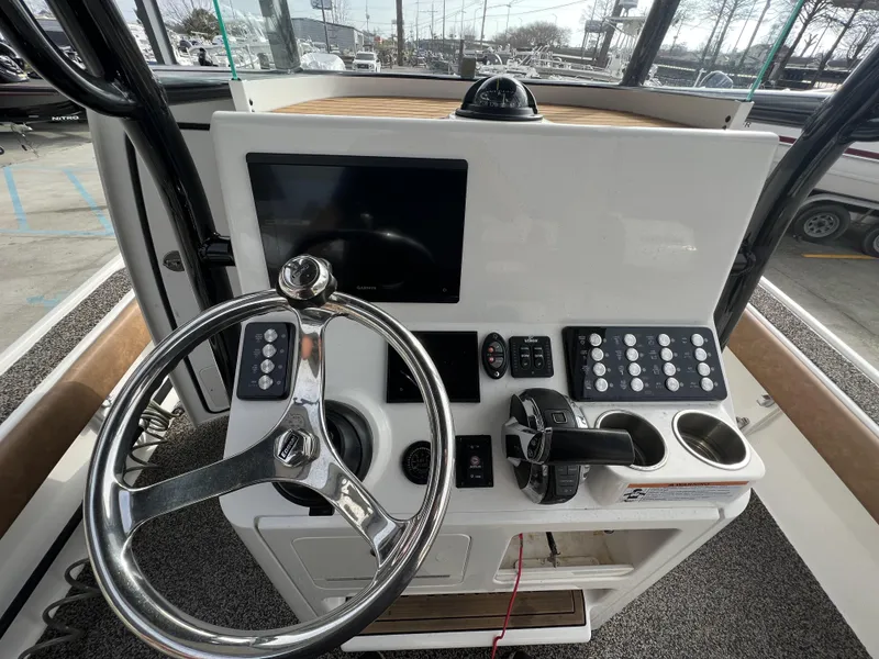 Slide: The Image of 2021 Caymas 26 HB boat dashboard with steering wheel, controls, and display screen. - 9