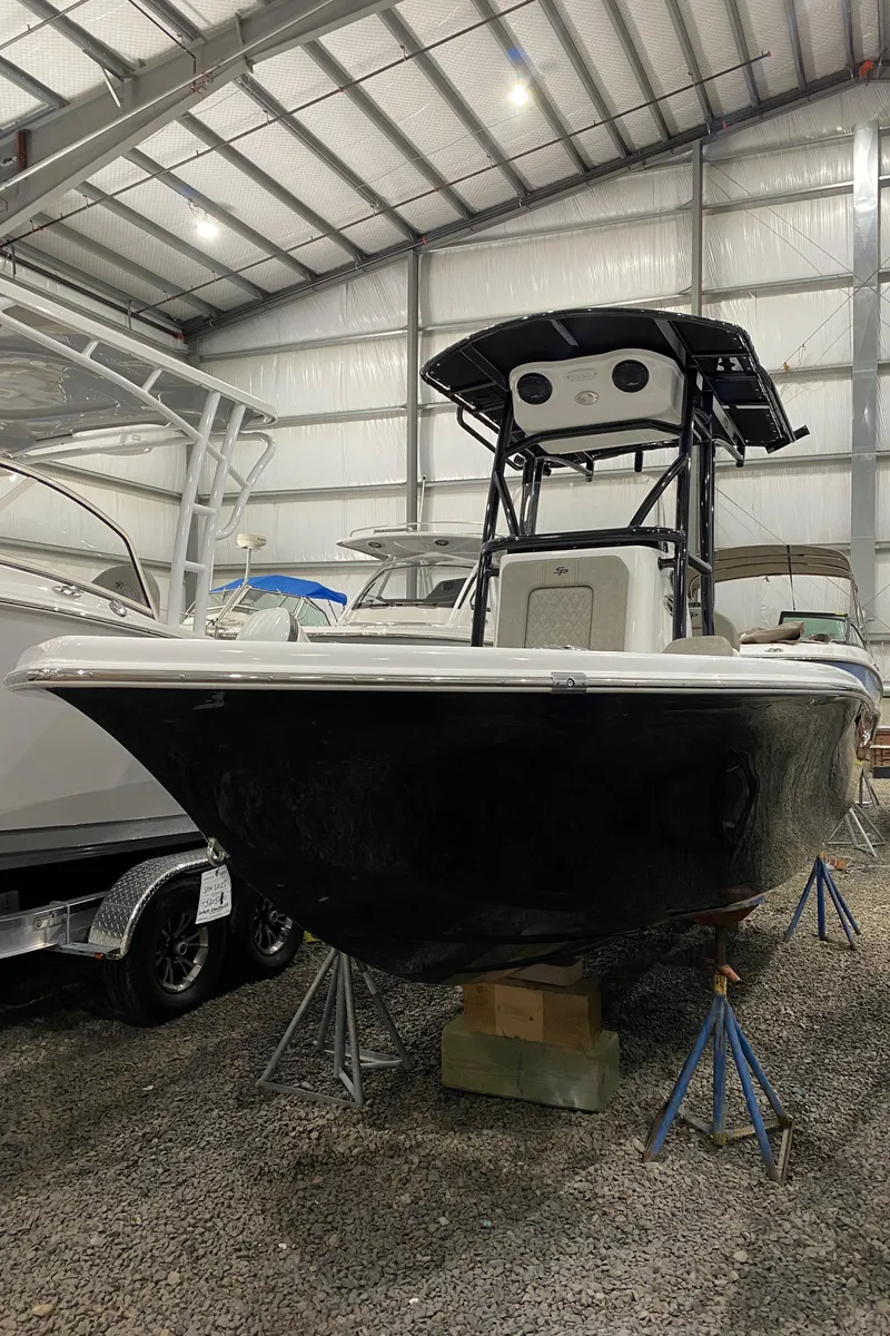 Slide: The Image of 2024 Sea Pro 202 boat in storage, black hull, indoor facility. - 0