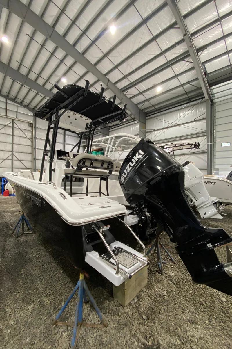 Slide: The Image of 2024 Sea Pro 202 boat with Suzuki engine in a storage facility. - 2