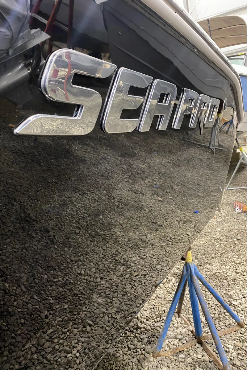 Slide: The Image of 2024 Sea Pro 202 boat side view with chrome logo on black hull. - 3