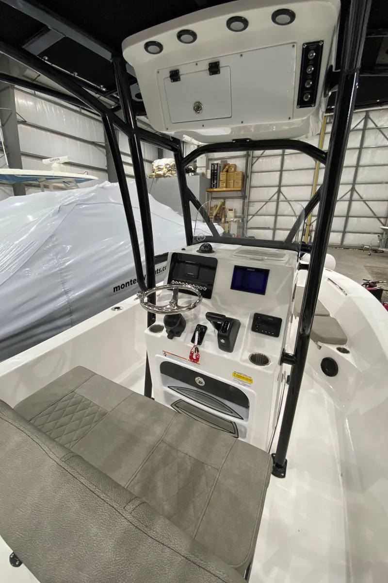 Slide: The Image of 2024 Sea Pro 202 boat console with modern controls and seating in a warehouse. - 4