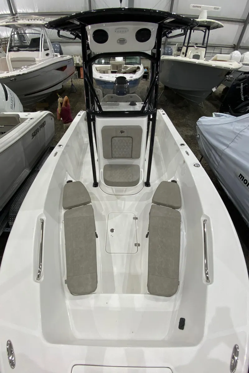 Slide: The Image of 2024 Sea Pro 202 boat interior with seating and console, displayed in a showroom. - 7