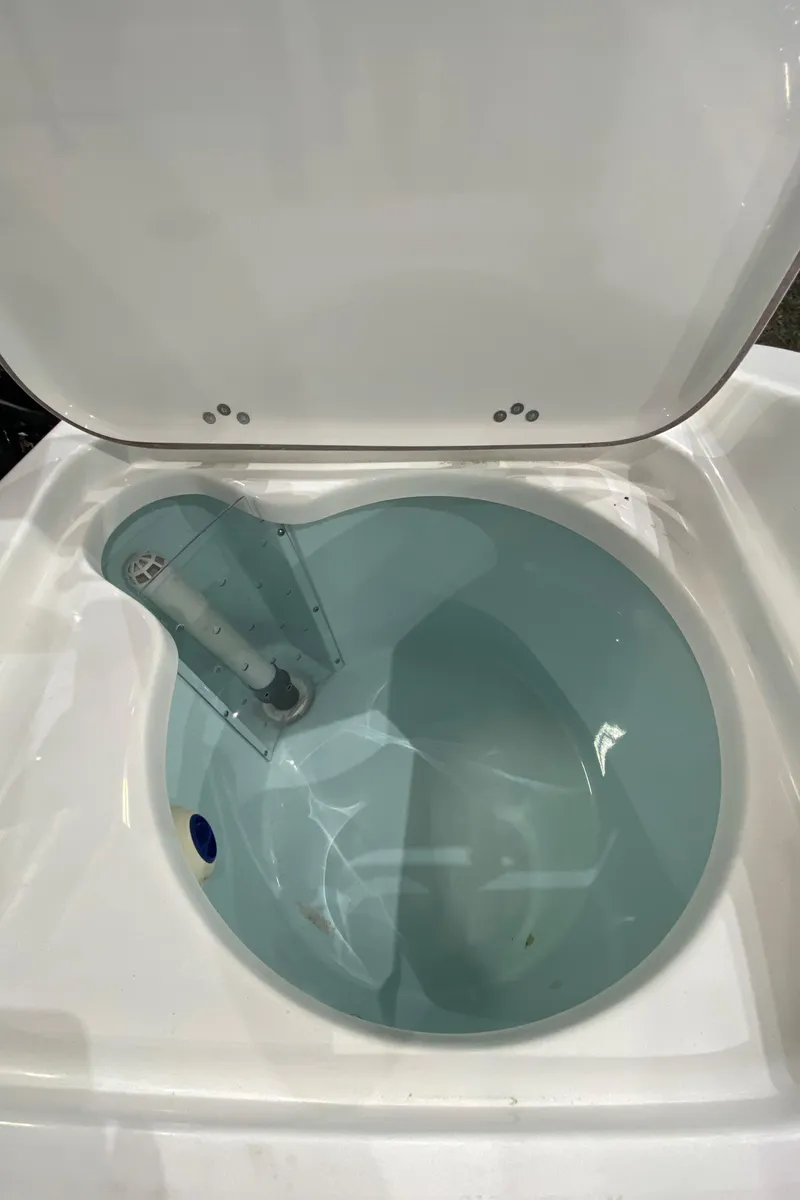 Slide: The Image of 2024 Sea Pro 202 boat livewell with open lid, showcasing interior design. - 8