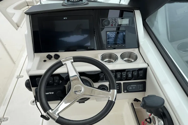 Slide: The Image of 2022 Boston Whaler 240 Vantage helm with steering wheel, navigation screens, and controls. - 10