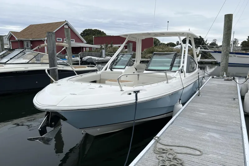 Slide: The Image of 2022 Boston Whaler 240 Vantage docked at a marina. - 2