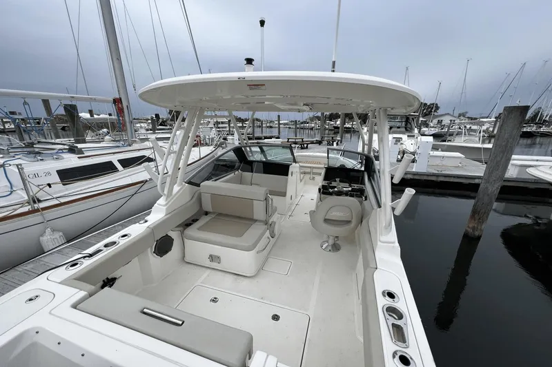 Slide: The Image of 2022 Boston Whaler 240 Vantage boat interior at marina, showcasing seating and helm. - 23