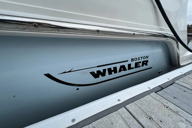 Slide: The Image of 2022 Boston Whaler 240 Vantage boat docked, close-up of logo on hull. - 24