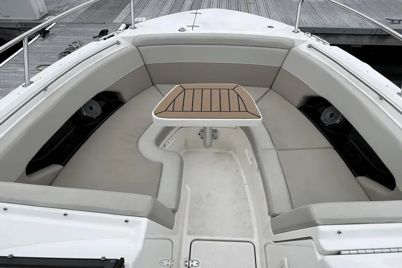Slide: The Image of 2022 Boston Whaler 240 Vantage boat interior with cushioned seating and a central table. - 5