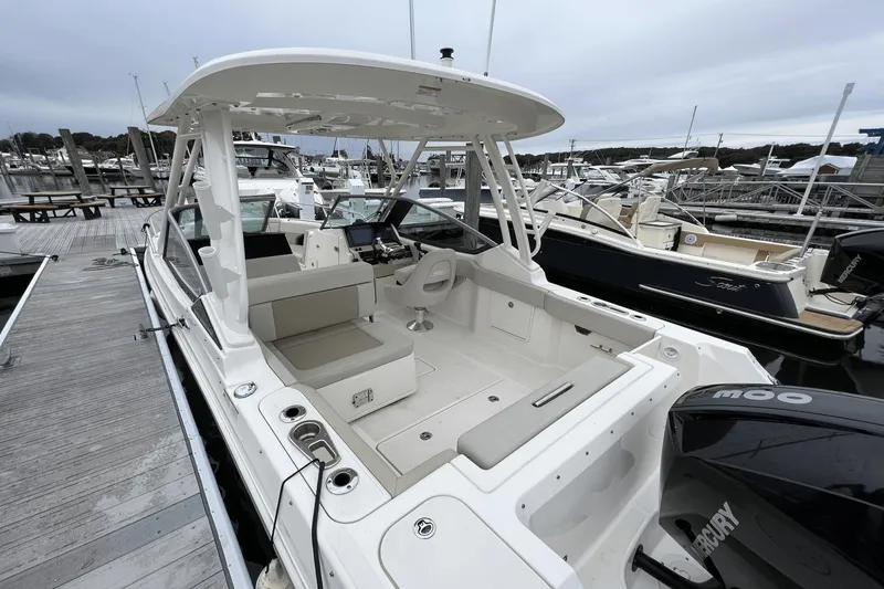 Slide: The Image of 2022 Boston Whaler 240 Vantage boat docked at a marina, showcasing its spacious seating and modern design. - 8