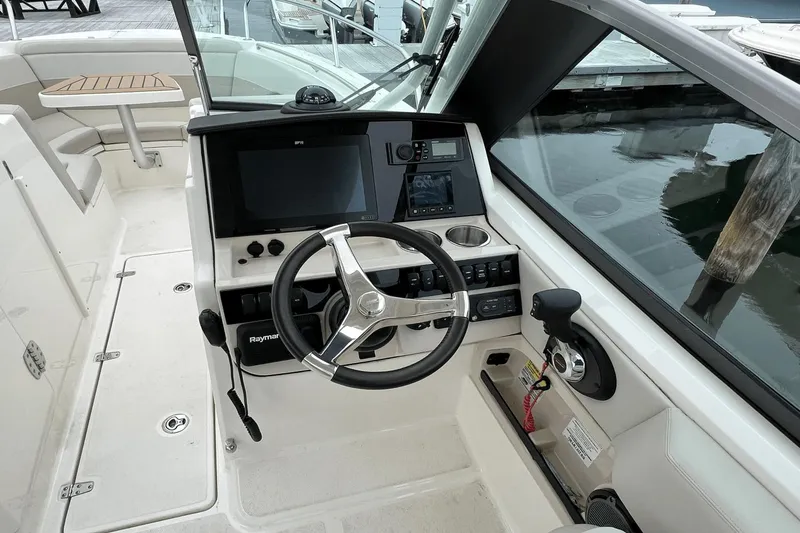 Slide: The Image of 2022 Boston Whaler 240 Vantage boat cockpit with steering wheel and navigation controls. - 9