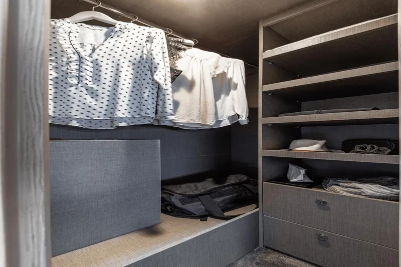 Slide: The Image of Luxurious closet interior on 2024 Azimut 53 Fly yacht, featuring organized shelves and hanging clothes. - 37