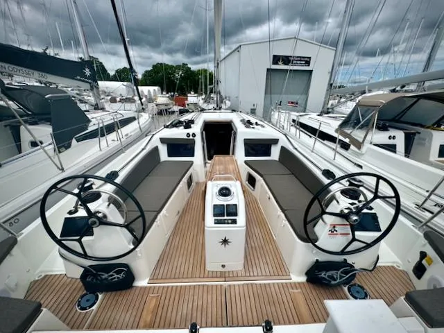 Slide: The Image of 2024 Jeanneau Sun Odyssey 410 sailboat cockpit with dual steering wheels and teak decking. - 0