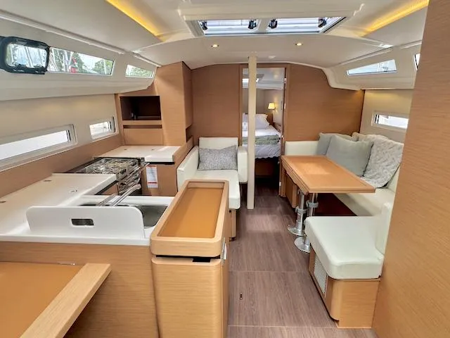 Slide: The Image of 2024 Jeanneau Sun Odyssey 410 interior, featuring modern kitchen and cozy seating area. - 14