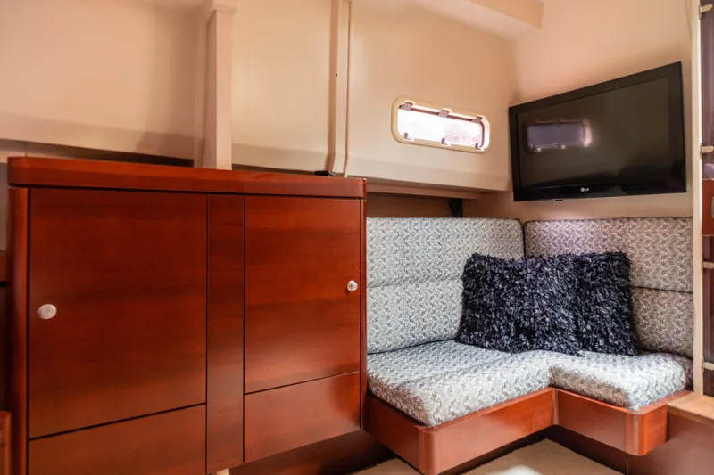Slide: The Image of Interior of 2008 Fjord Express yacht with wooden cabinetry, cushioned seating, and wall-mounted TV. - 19