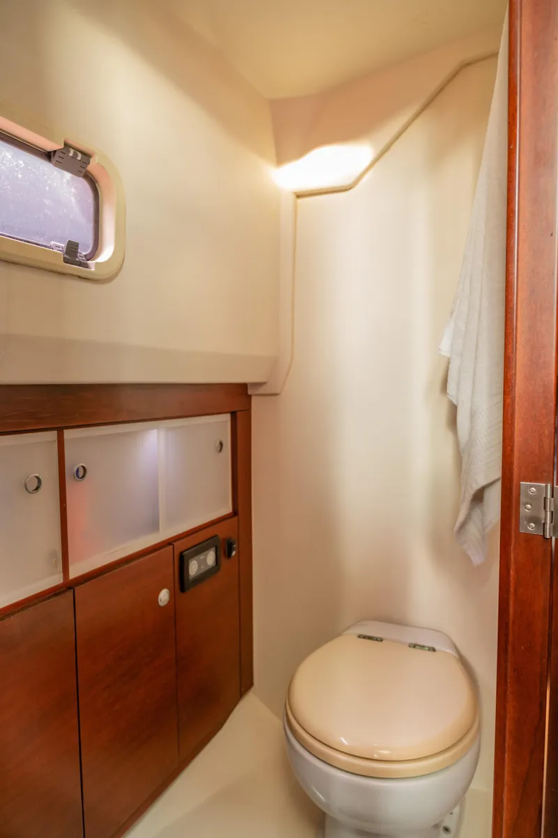Slide: The Image of 2008 Fjord Express boat bathroom with wooden cabinets and a porthole window. - 20
