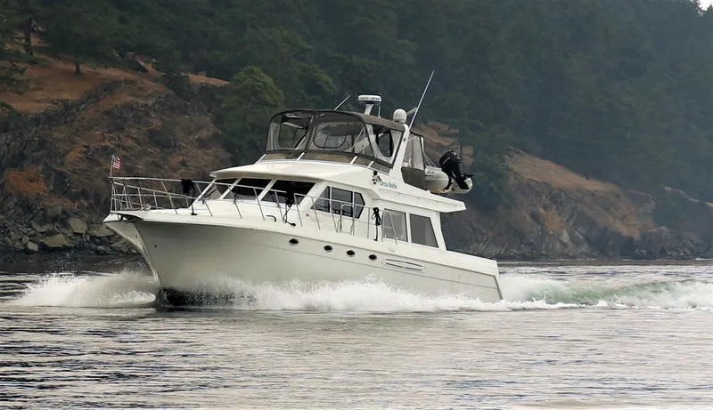 Slide: The Image of Navigator 5300 yacht cruising near forested shoreline, 2000 model. - 2