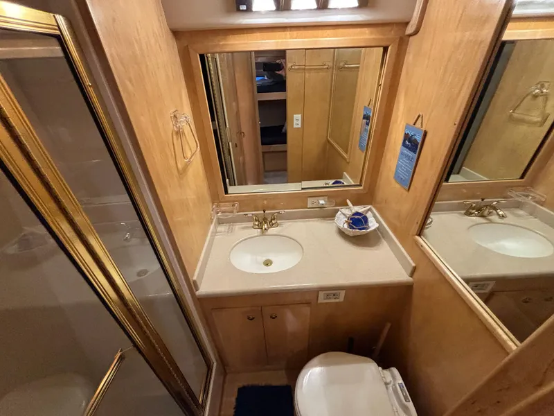 Slide: The Image of Luxurious bathroom in 2000 Navigator 5300 yacht with wood accents and gold fixtures. - 25