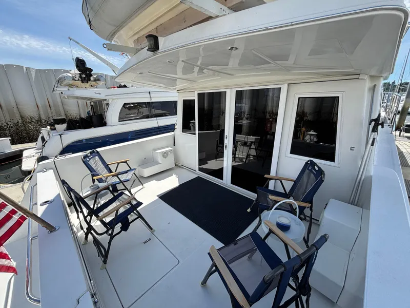 Slide: The Image of Navigator 5300 yacht deck, 2000 model, with chairs and American flag, docked at marina. - 5