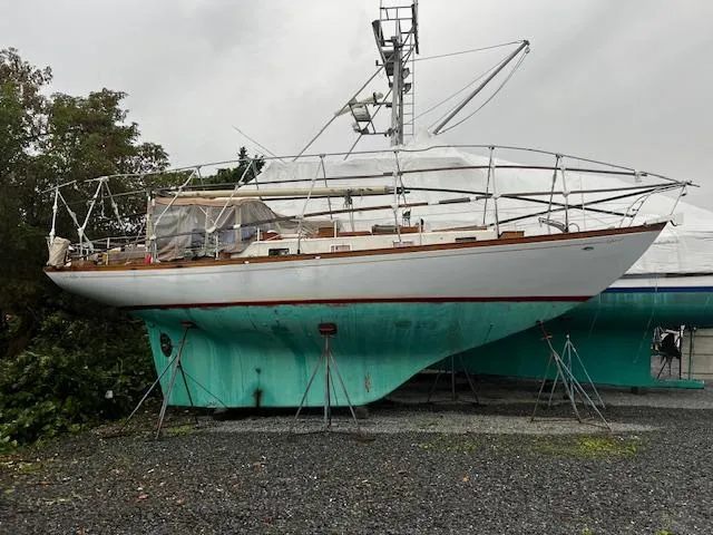 Slide: The Image of 1970 Cheoy Lee Offshore 40 sailboat under protective cover, showcasing deck and cabin details. - 2