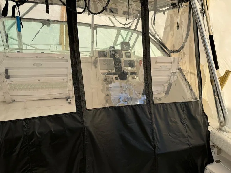 Slide: The Image of Interior view of a 2000 Rampage 30 Express boat cockpit with clear vinyl enclosure. - 8