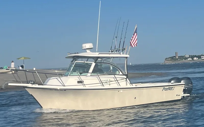 The Image of 2015 Parker 2510 XL Walkaround boat cruising on water with fishing rods and American flag. - 0
