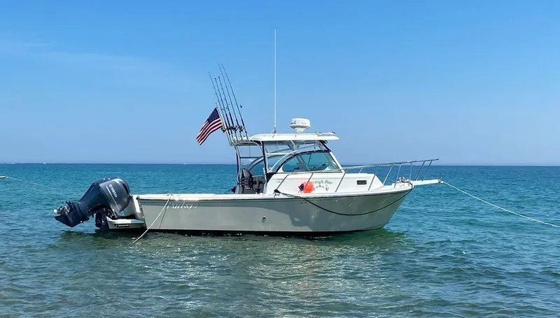 Slide: The Image of 2015 Parker 2510 XL Walkaround boat anchored in clear blue water. - 2