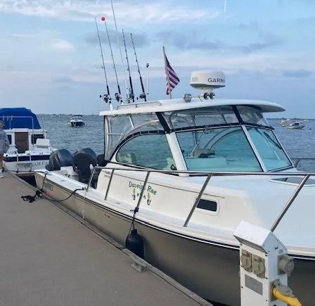 Slide: The Image of 2015 Parker 2510 XL Walkaround boat docked, equipped with fishing rods and Garmin radar. - 3