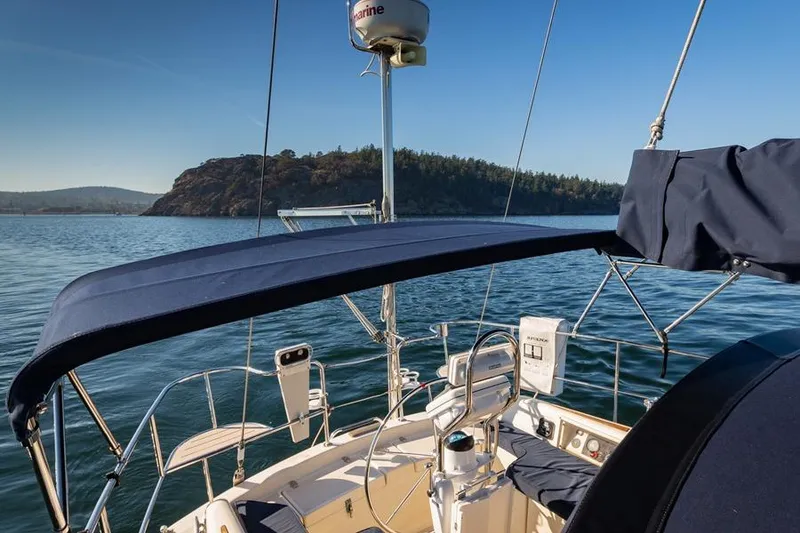 Slide: The Image of Sailboat Caliber 40 (2002) on serene water with scenic island backdrop. - 11