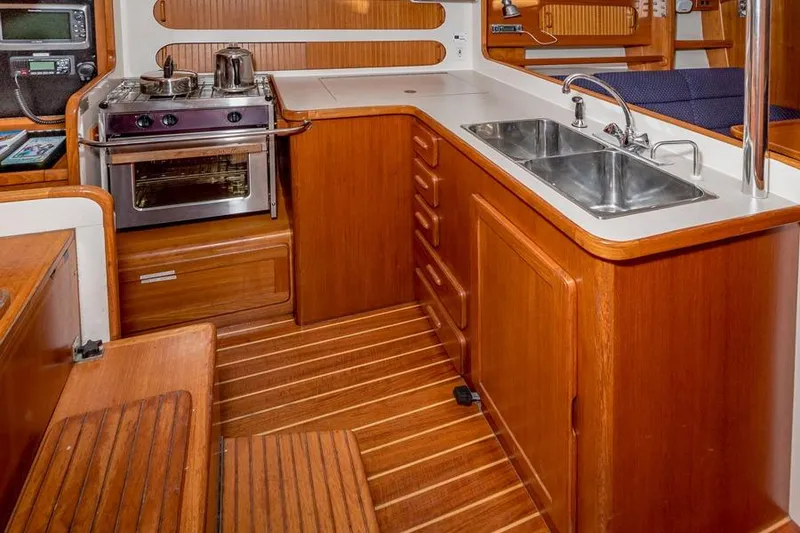 Slide: The Image of Wooden yacht kitchen interior with stove, double sink, and storage, Caliber 40, 2002 model. - 17