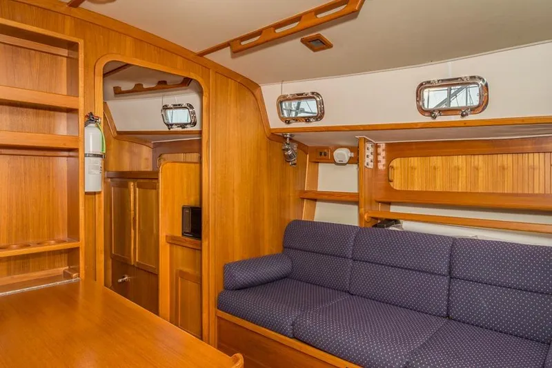 Slide: The Image of Interior of 2002 Caliber 40 sailboat with wooden cabinetry and blue upholstered seating. - 20