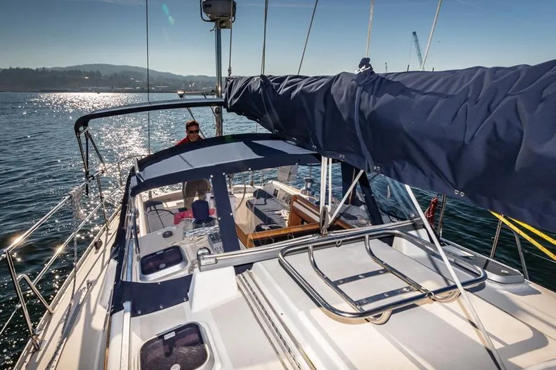Slide: The Image of 2002 Caliber 40 sailboat on water, sunny day, person at helm, scenic background. - 22