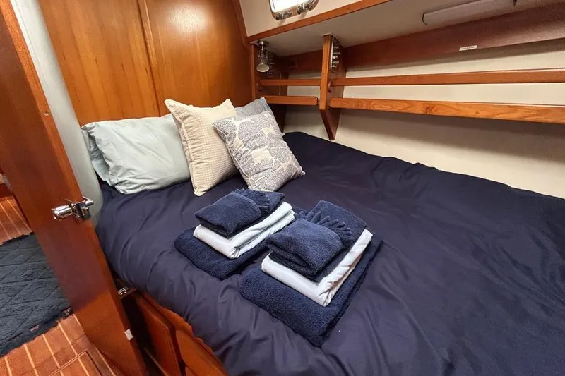 Slide: The Image of Cozy cabin interior of 2002 Caliber 40 yacht with neatly arranged bedding and towels. - 5