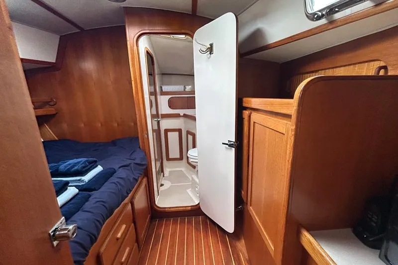 Slide: The Image of 2002 Caliber 40 yacht interior with wooden cabin, bed, and bathroom. - 6