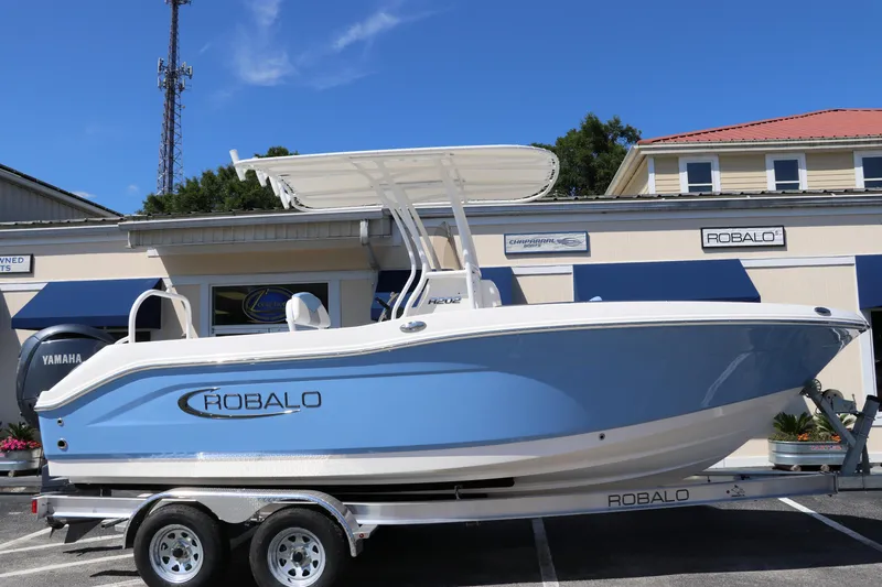 Slide: The Image of 2024 Robalo R202 EX boat on a trailer, displayed outdoors. - 1