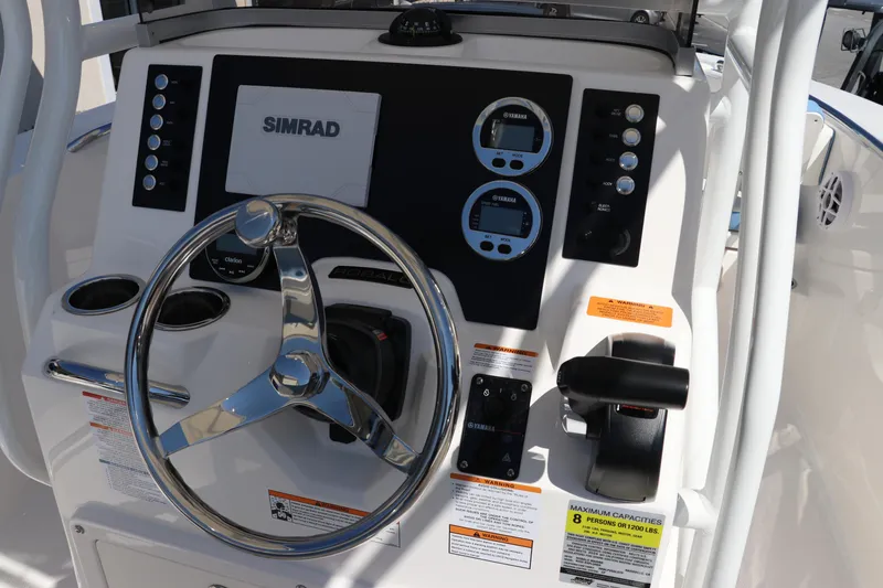 Slide: The Image of 2024 Robalo R202 EX boat dashboard with Simrad display and steering wheel. - 11