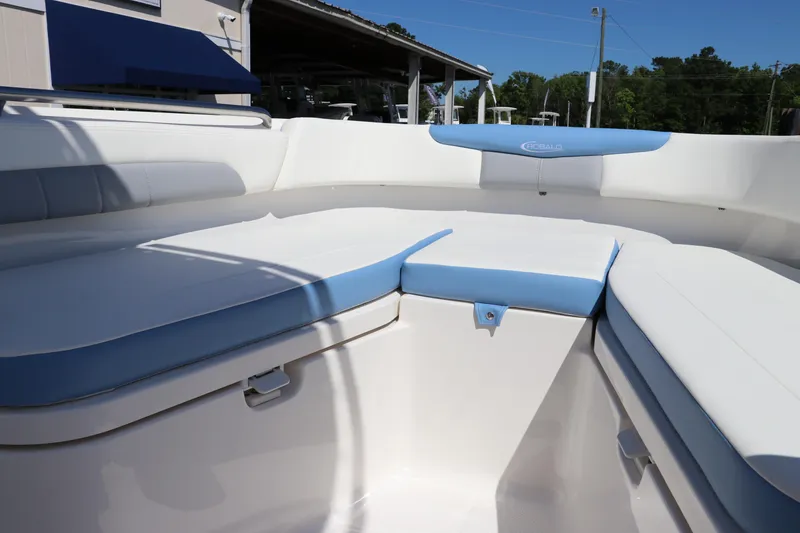 Slide: The Image of 2024 Robalo R202 EX boat interior with white and blue cushioned seating. - 14