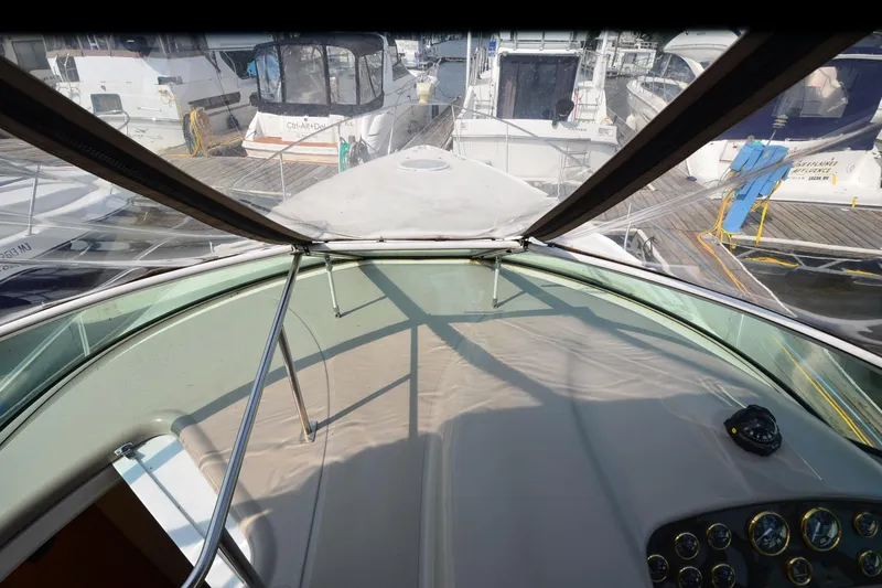 Slide: The Image of 2004 Cruisers Yachts 320 Express cockpit view at marina, showcasing dashboard and windshield. - 11