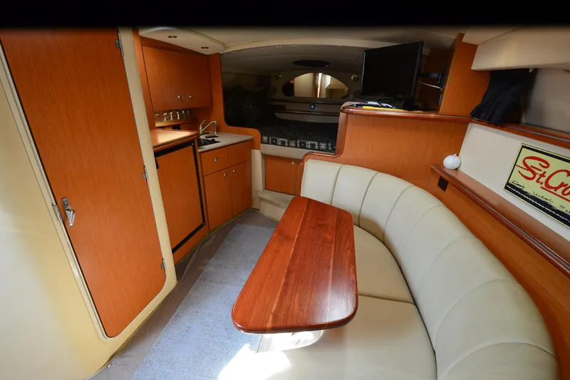 Slide: The Image of Interior of 2004 Cruisers Yachts 320 Express with wood cabinetry and beige seating. - 15