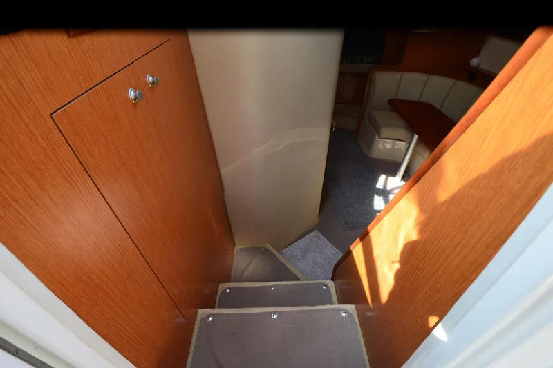 Slide: The Image of 2004 Cruisers Yachts 320 Express interior with wooden cabinetry and seating area. - 17