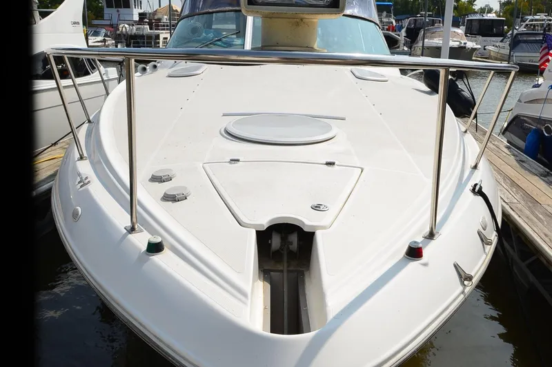 Slide: The Image of 2004 Cruisers Yachts 320 Express boat docked at marina, front deck view. - 2