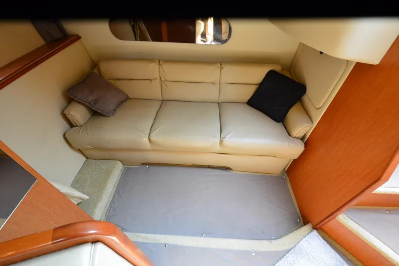 Slide: The Image of 2004 Cruisers Yachts 320 Express interior with beige leather sofa and cushions. - 20